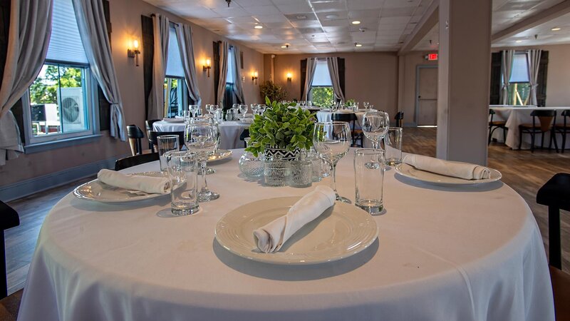 Private event room with focus on round table set for five guests