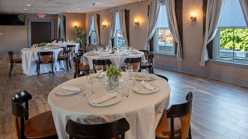 Three round tables set for guests in private party room